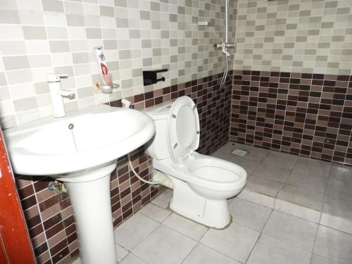 a bathroom with a toilet and a sink at MJ Hosting in Dar es Salaam