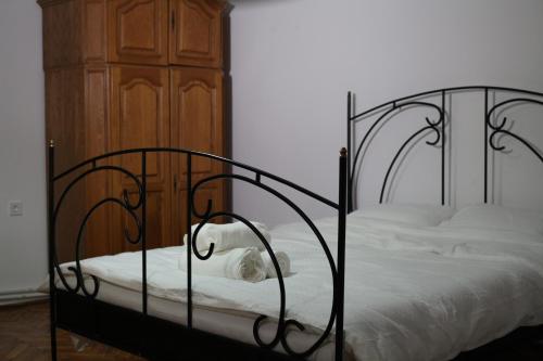1 dormitorio con cama negra con sábanas blancas en FeriAna Residence, en Miercurea-Ciuc