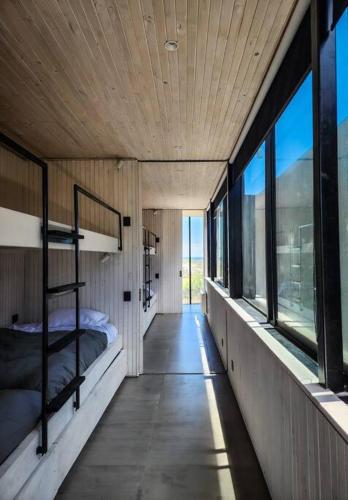 a bedroom with two bunk beds and windows at Casa Box, Punta de Lobos in Pichilemu