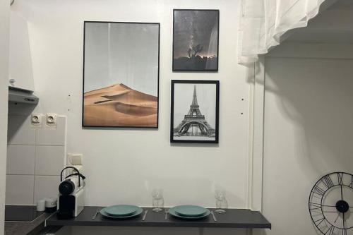 a kitchen with pictures on a wall with a table at Cozy studio in Paris 15eme in Paris