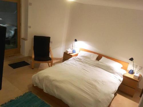 a bedroom with a white bed and a chair at Self-contained, private entrance, near city centre in Norwich