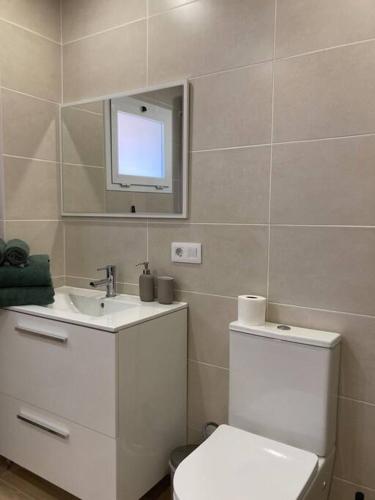 a bathroom with a toilet and a sink and a mirror at Cosy ocean view studio 2 in San Marcos