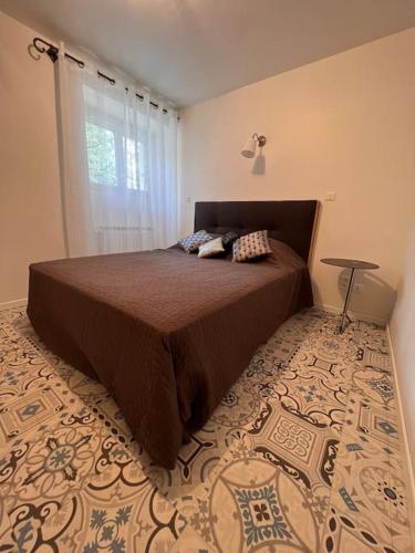 une chambre avec un grand lit avec une fenêtre dans l'établissement Maison Meublée Montignac-Lascaux, à Montignac