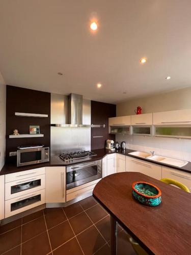 - une grande cuisine avec une table en bois et une table sidx sidx sidx dans l'établissement Maison Meublée Montignac-Lascaux, à Montignac