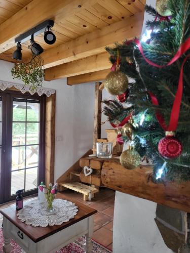 a christmas tree in a room with a table at Zagroda Krasna in Polańczyk