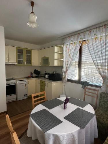 una cucina con tavolo e tovaglia bianca di Snow House a Bansko