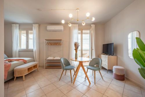 a room with a bed and a table and chairs at Zefiro Apartments in San Vincenzo
