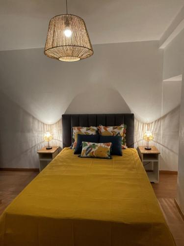 a bedroom with a large yellow bed with two lamps at Alojamento Local - Casa Zé Santos - Aldeias do Xisto - Sobral de São Miguel - Covilhã in Sobral de São Miguel