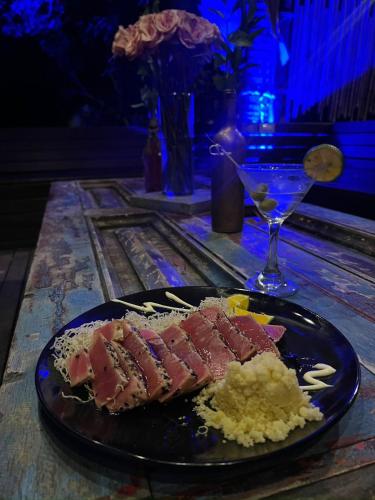 a plate of food with meat and a drink on a table at Ibuku Hotel Guatapé - Chalets in Guatapé
