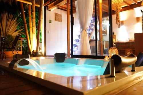 瓜塔佩的住宿－Ibuku Hotel Guatapé - Chalets，一个带椅子和桌子的房间的热水浴缸