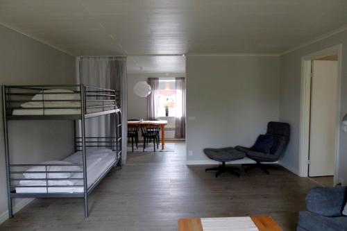 a room with bunk beds and a living room with a table at Åsbergbo Vandrarhem in Vallsta