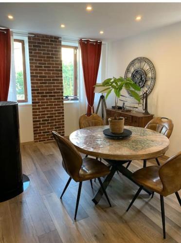 une salle à manger avec une table, des chaises et une plante dans l'établissement La campagne à 30 min de Paris !, à Dammartin-en-Goële