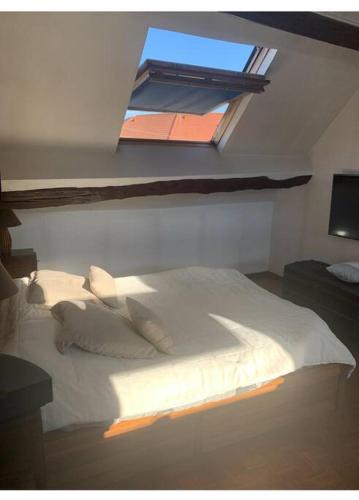 une chambre avec un grand lit blanc avec une fenêtre dans l'établissement La campagne à 30 min de Paris !, à Dammartin-en-Goële