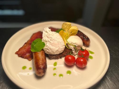 a white plate of food with sausage and other foods at Zoe Bistro & Accommodation in Kilrush