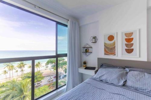 um quarto com uma grande janela com vista para a praia em Flats de Luxo by BnbFlex - Costa Vicentina no Recife