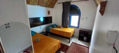 una camera con letto e specchio di Nile View (2) Guest House a Aswan