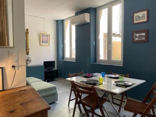 un salon avec une table et des chaises et un mur bleu dans l'établissement Marseille Côté Cour, à Marseille