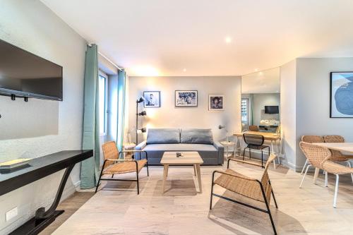 a living room with a couch and chairs and a table at Résidence Les Halles charmant 1 chambre Bocuse Part Dieu in Lyon