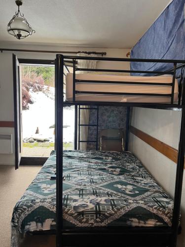 sypialnia z łóżkiem piętrowym i narzutą w obiekcie Le Grattague - St Gervais Les Bains w mieście Saint-Gervais-les-Bains
