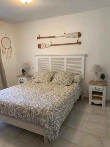 a bedroom with a bed and two night stands and two tables at Suite dans un petit paradis in La Londe-les-Maures
