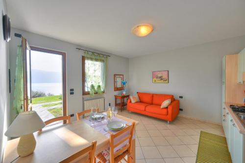 a living room with an orange couch and a table at Agriturismo L'Uliveto in Gargnano