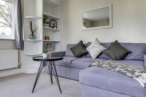 ein Wohnzimmer mit einem lila Sofa und einem Tisch in der Unterkunft Hatfield Uni - Free Parking - Business, Families in Hatfield