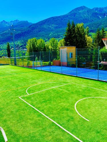 a tennis court with a net on top of it at Bijoux Des Alpes - Mont Blanc Village in La Salle