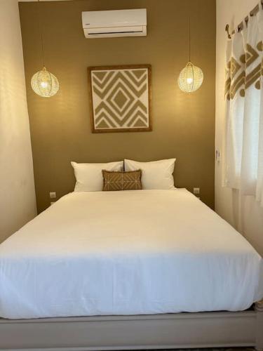 um quarto com uma grande cama branca e 2 luzes em Riad ROSE private Riad with jacuzzi em Marrakech