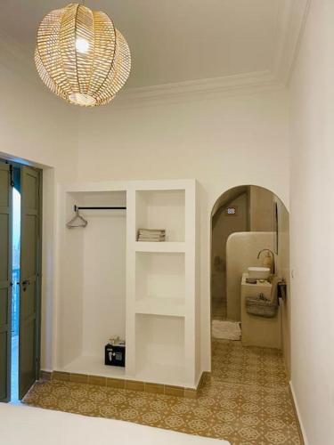 um quarto com uma parede branca com um lustre em Riad ROSE private Riad with jacuzzi em Marrakech