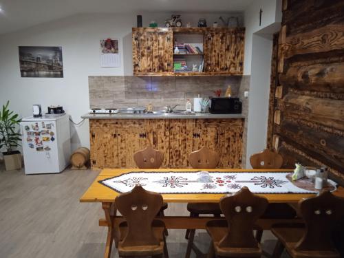 a kitchen with a wooden table with chairs and a sink at Wypoczynek u Agnieszki in Ochotnica Górna