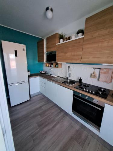 una cucina con elettrodomestici bianchi e armadietti in legno di Residence La Fenice a Vasto