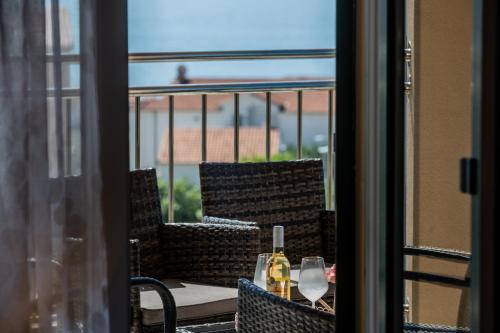 uma mesa com dois copos de vinho numa varanda em Sun Island Apartment em Trogir