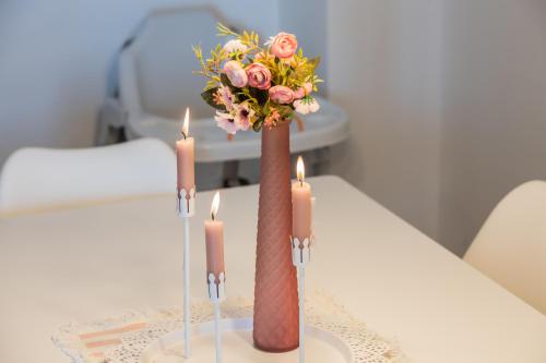 um vaso com flores e velas sobre uma mesa em Sun Island Apartment em Trogir