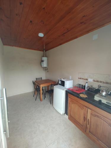 a kitchen with a stove and a sink and a table at Departamentos Rimasha in Federación