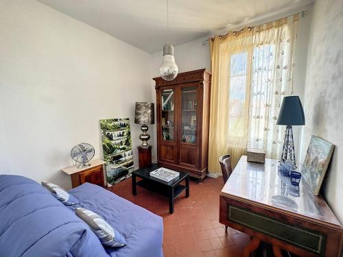 salon z niebieską kanapą i stołem w obiekcie Très belle maison avec jardin à 10min des remparts w Awinionie