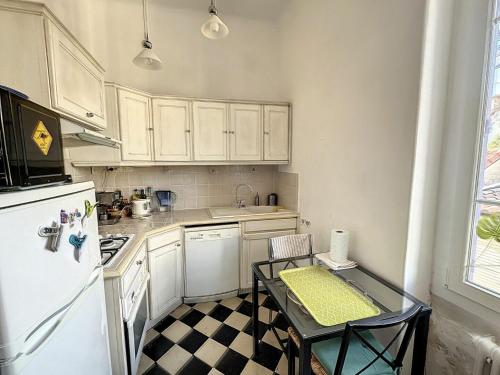 - une cuisine avec un sol en damier noir et blanc dans l'établissement Très belle maison avec jardin à 10min des remparts, à Avignon