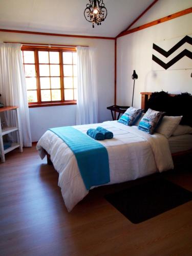 a bedroom with a large bed with blue pillows at Havana Nights in Graskop