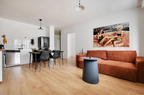 a living room with a couch and a table and a kitchen at Charming Apartment in Saint-Ouen - GetHosted in Saint-Ouen