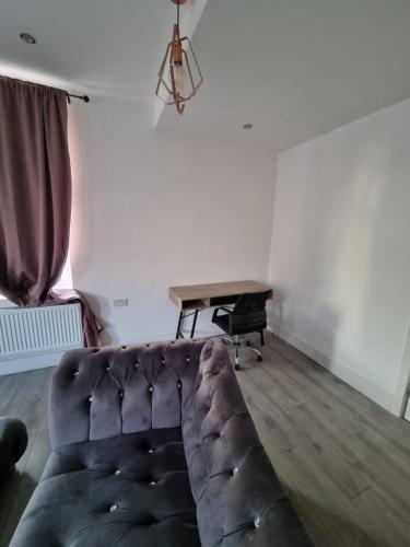 uma sala de estar com um sofá e uma mesa em 1 Bed Flat In Levenshulme em Manchester