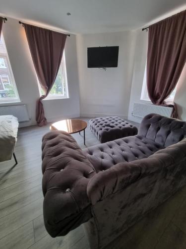 a living room with a large couch and a tv at 1 Bed Flat In Levenshulme in Manchester