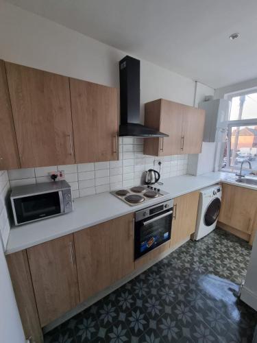 uma cozinha com um lavatório e um fogão forno superior em 1 Bed Flat In Levenshulme em Manchester