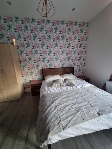 a bedroom with a bed with a floral wallpaper at 1 Bed Flat In Levenshulme in Manchester