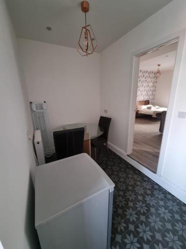 a room with a white table and chairs and a bedroom at 1 Bed Flat In Levenshulme in Manchester