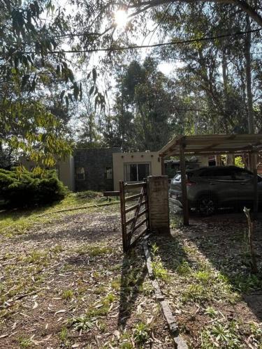 ein Zaun vor einem Haus mit einem Auto in der Unterkunft Casa en bella vista, Clarita in Bella Vista