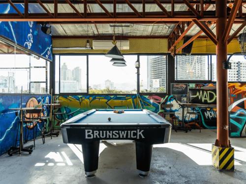 a pool table in a room with graffiti at Mad Monkey Cebu City in Cebu City