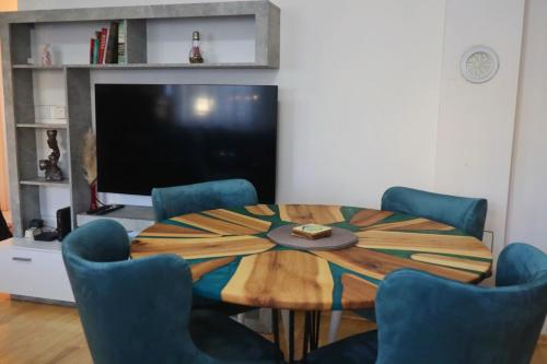 Un comedor con mesa y sillas y un televisor. en NARO Home Sarajevo, en Sarajevo