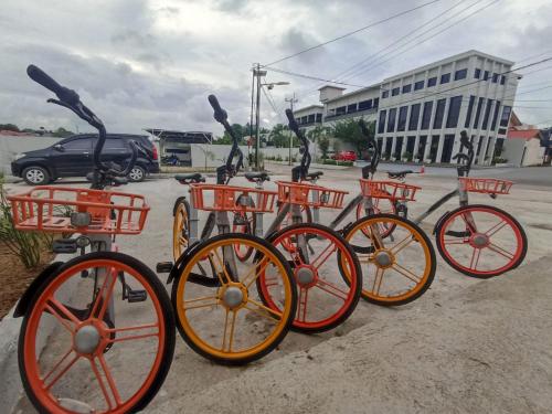 a group of orange bikes parked in a parking lot at ONYX HOTEL & VILLA in Tanjunguban