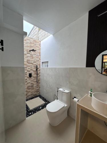 a bathroom with a white toilet and a sink at Boli Villa Thoddoo in Thoddoo