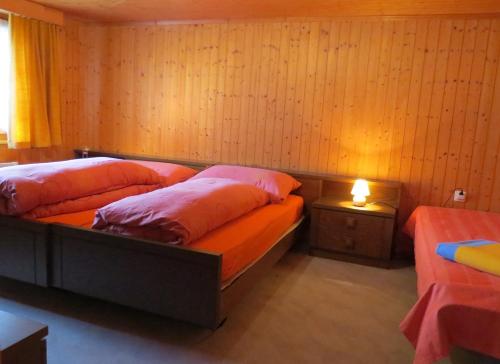 - une chambre avec 2 lits avec des oreillers roses dans l'établissement Adli, à Disentis
