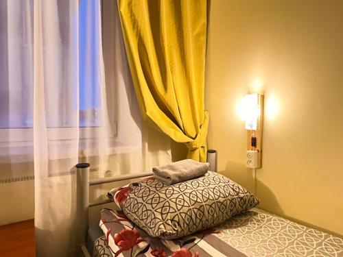 a bed in a room with a yellow curtain at Fry House in Warsaw